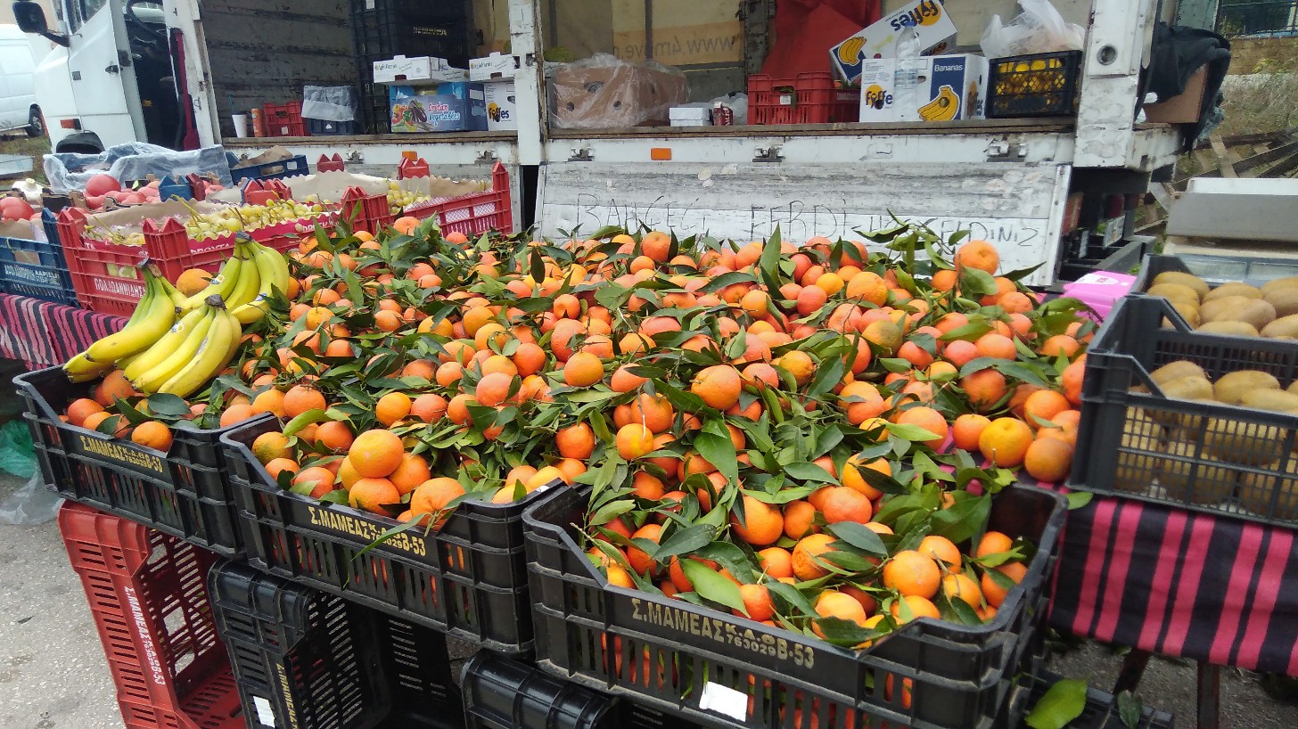 Gleaming oranges (bananas and potatoes) on a market stall in Northern Greece