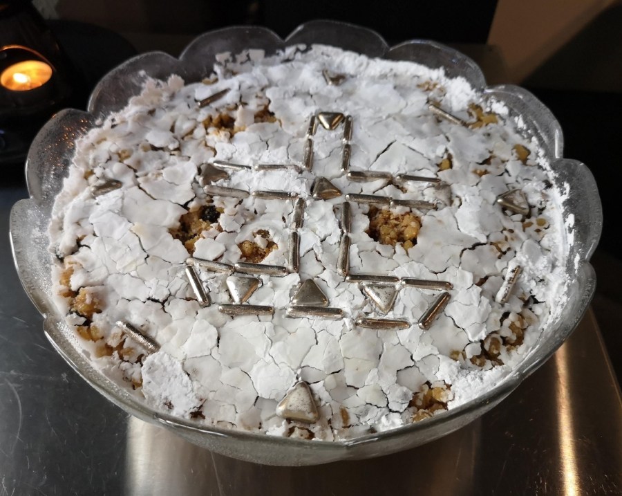 Funeral cake with white sugar and silver cross on top
