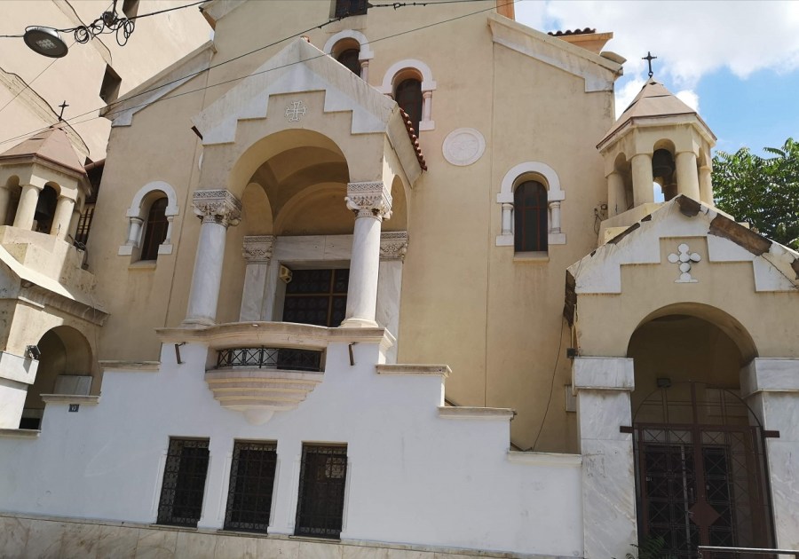 Beige and white Greek Orthodox Church with columns, turrets, crosses and stepped entrance