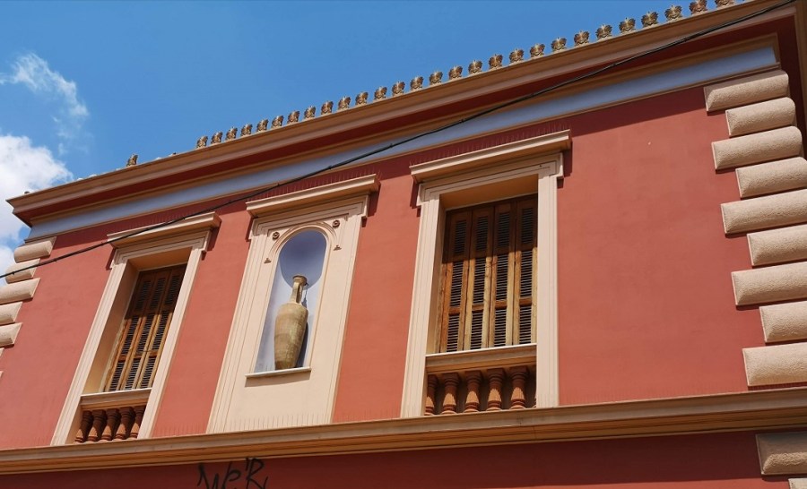Pink facade with Greek urn, 2 windows and decorated roof