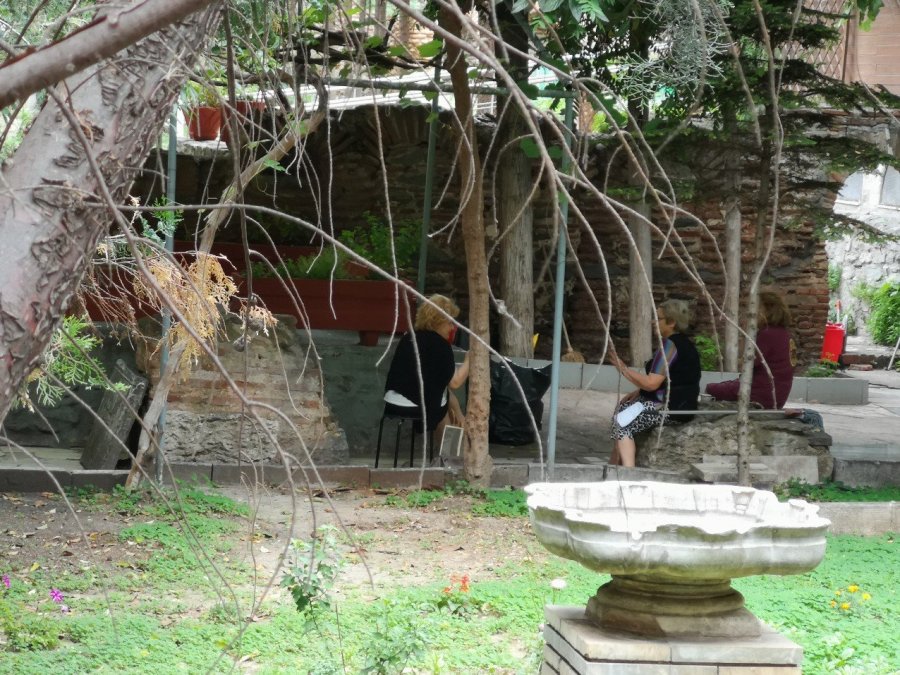 Women in black clothes chatting by trees 