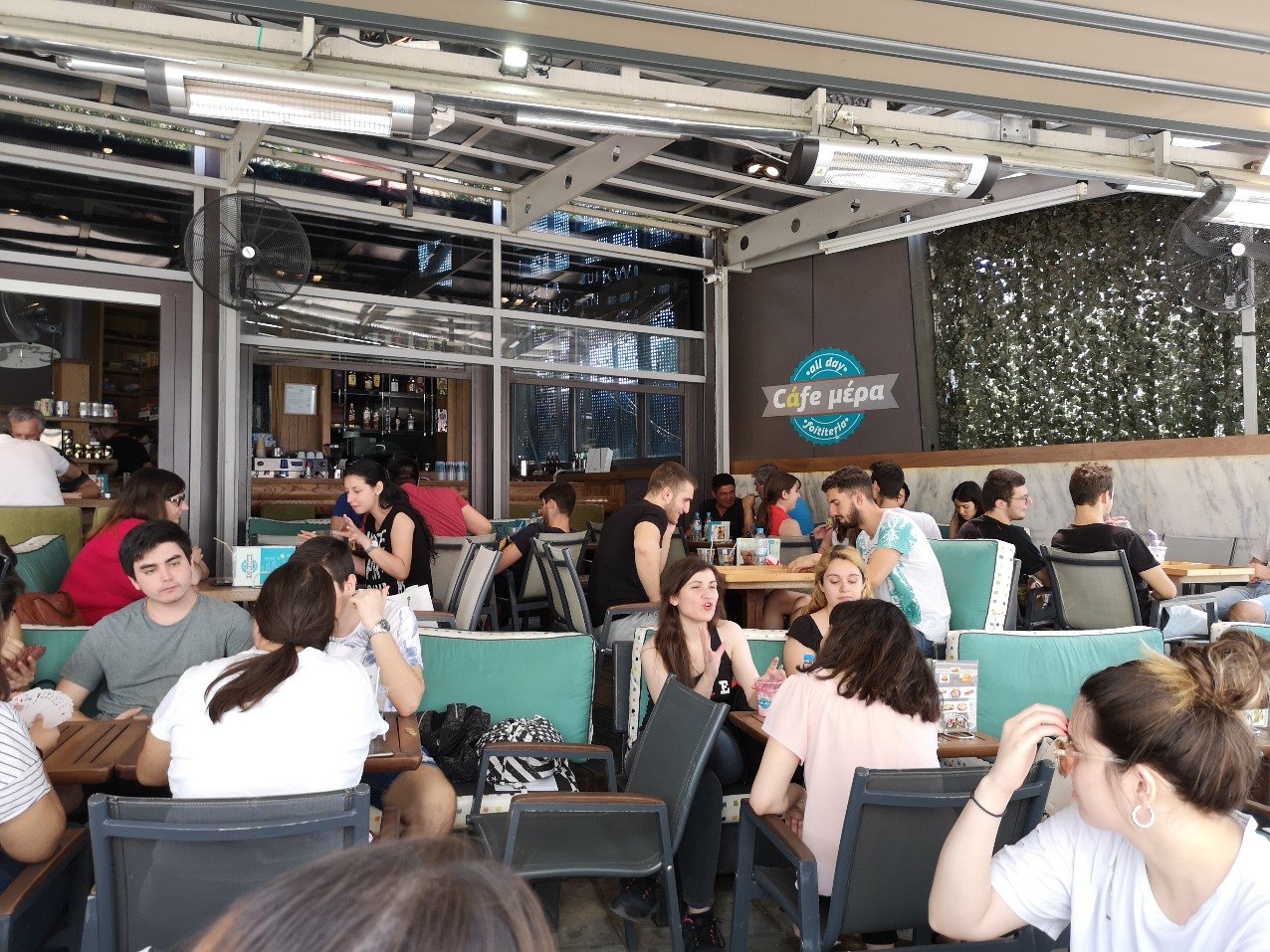 People sitting at tables with drinks 