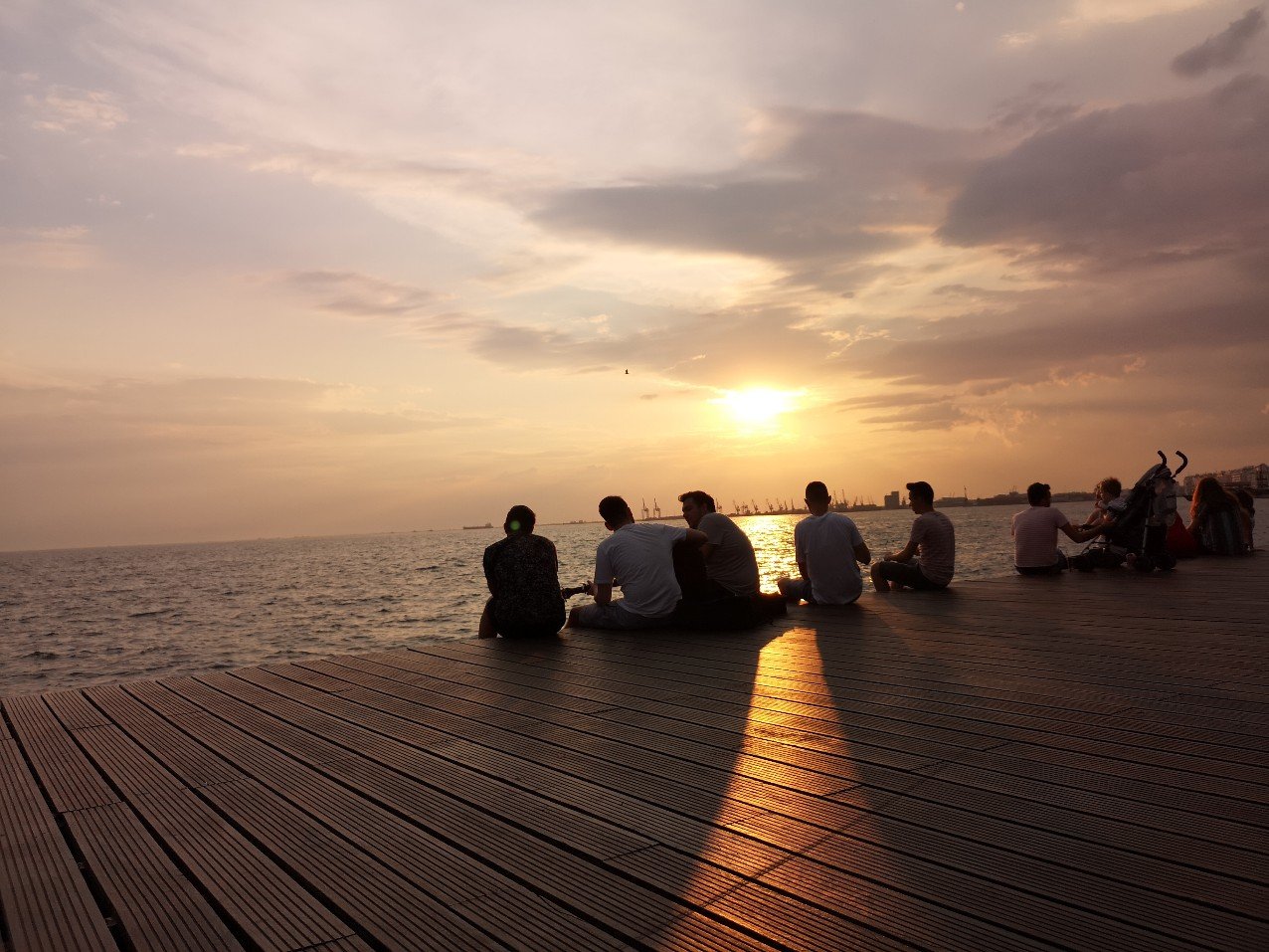 Men sitting on edge sea 