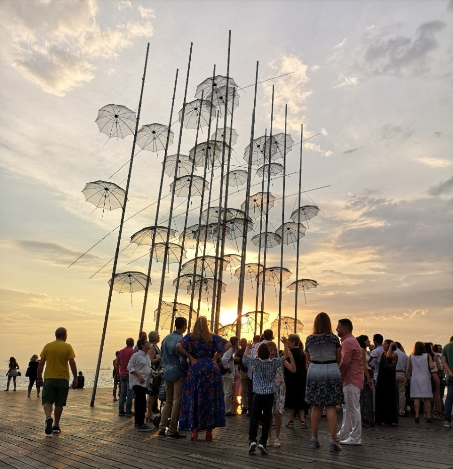 People standing under tall metal umbrellas 