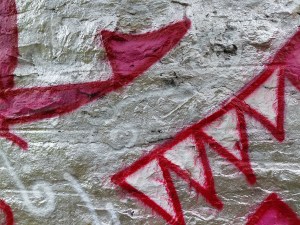 Two images of graffiti, one a tear shape and the other like the triangles representing a dragon
